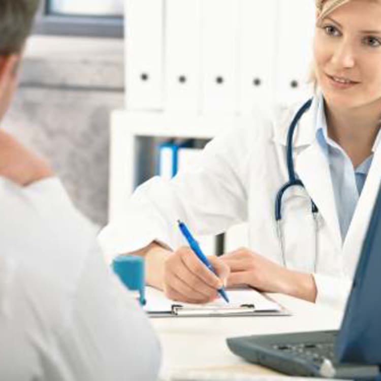 A doctor is discussing pain management with a patient at a desk.