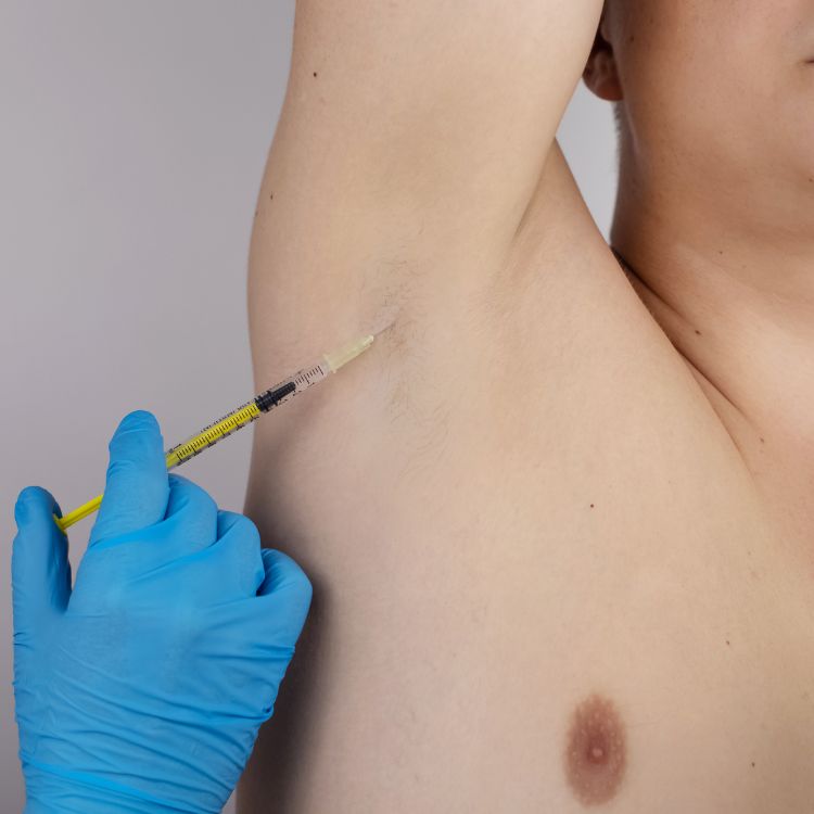 a man is getting a syringe injected into his arm to understand the causes of hidradenitis suppurativa.