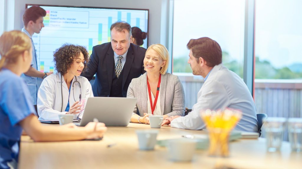 Mastering Hidradenitis Suppurativa Management: Clinical Epidemiology Insights a group of people sitting around a table in a conference room.
