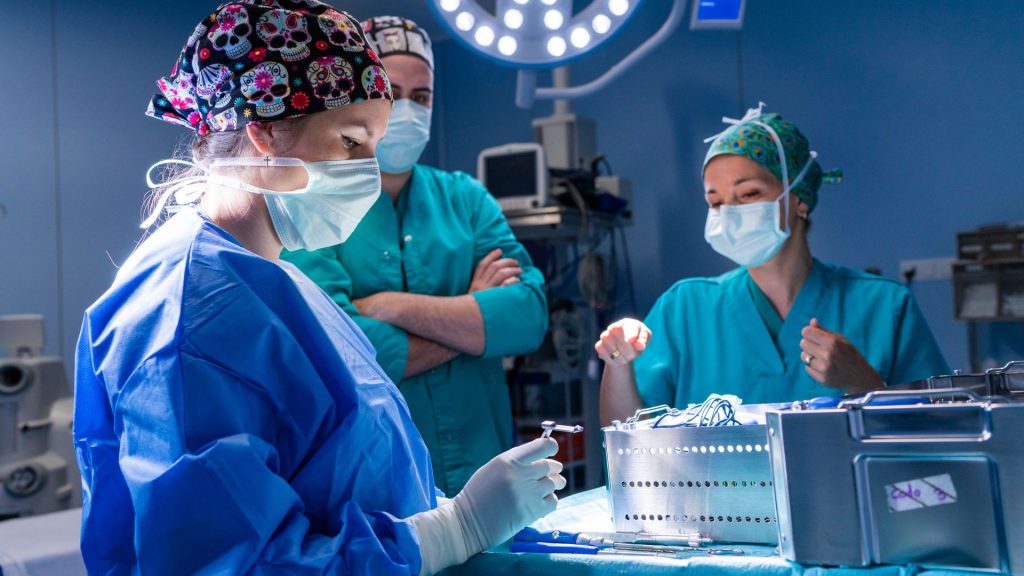 a group of surgeons specializing in hidradenitis suppurativa management working in an operating room.