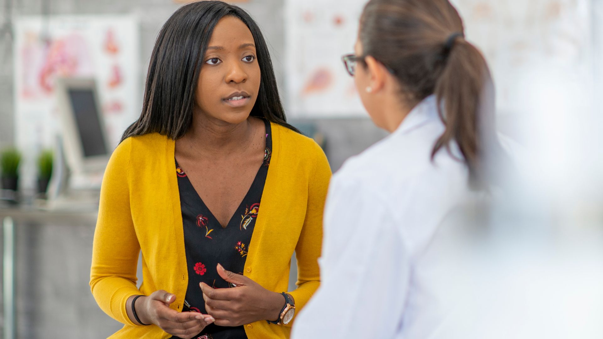 A woman discussing her skin condition with a doctor in a doctor's office, seeking treatment, Myths about Hidradenitis Suppurativa