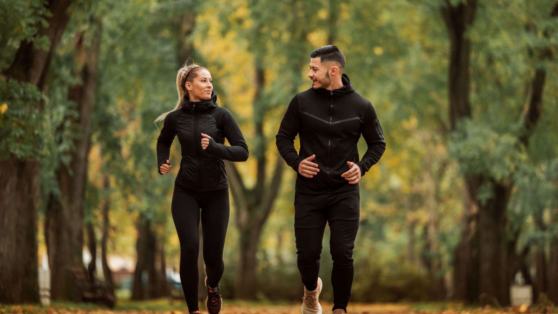 A man and woman jogging in the park.